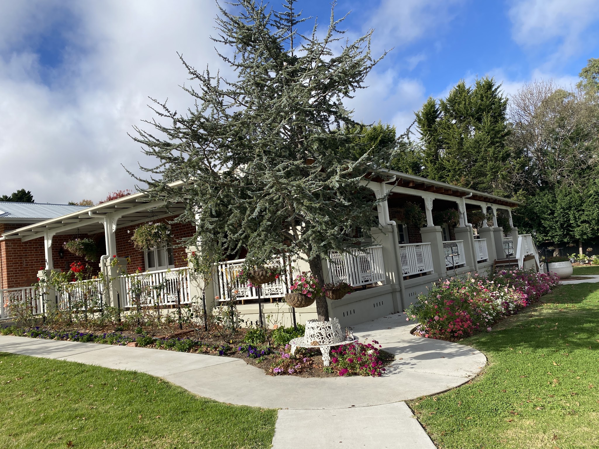 The heritage brick house with its white lace-iron veranda, rose beds and lawn